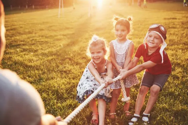 children-play-with-dad-in-the-park-they-pull-the-rope-and-have-fun-laying-on-sunny-day (1)